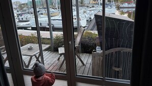 A view from a room with large windows overlooking a marina with multiple boats.