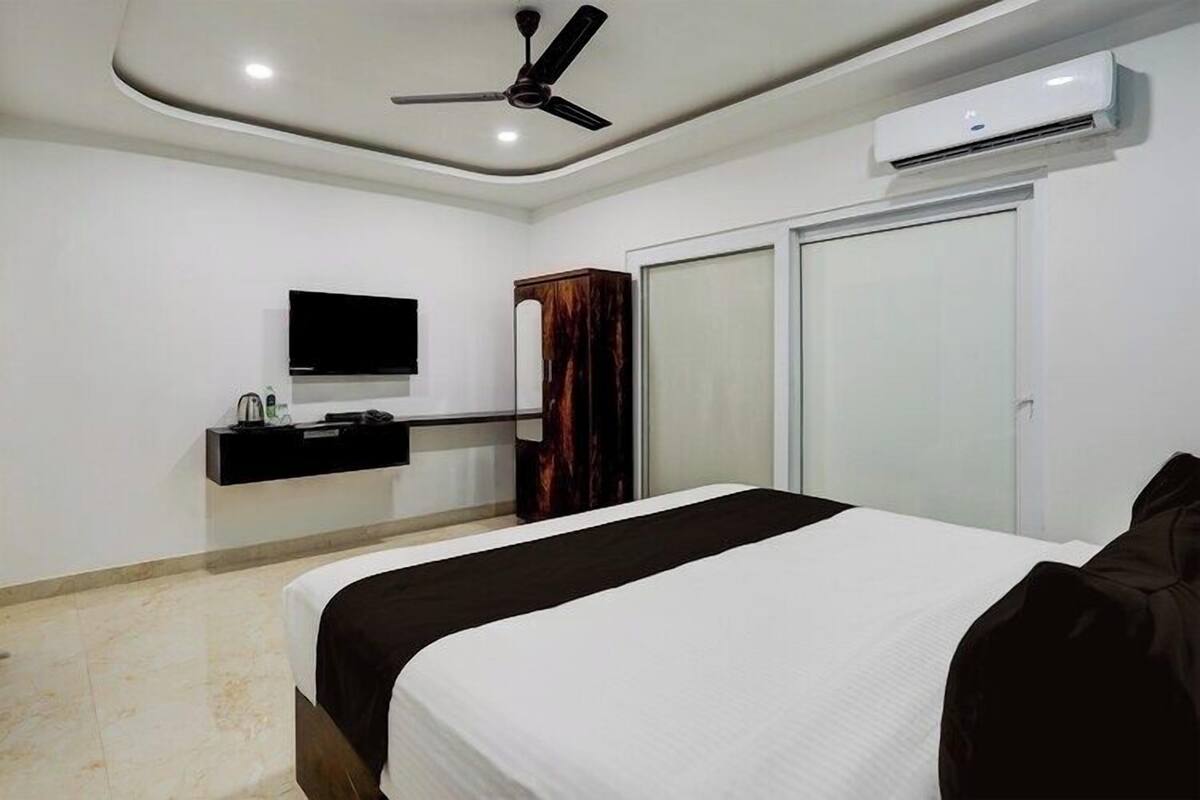 Une chambre à coucher comprenant un lit, une armoire, un téléviseur et un appareil de climatisation.