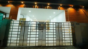 A gated entrance to a building with a modern design, featuring a metal gate and a series of lights above the entrance. - beestay Hotels Tirupati (Tirupati)