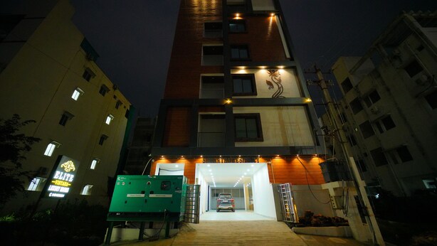 A multi-story building with a well-lit entrance and a car parked inside. - beestay Hotels Tirupati (Tirupati)