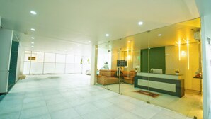 A spacious lobby with a reception desk, seating area, and a large glass wall. - beestay Hotels Tirupati (Tirupati)