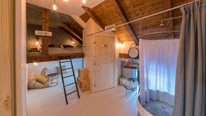 A cozy attic bedroom with a bunk bed, a ladder, a toilet, and a small bathroom. - Alter Schlachthof (Bressanone)