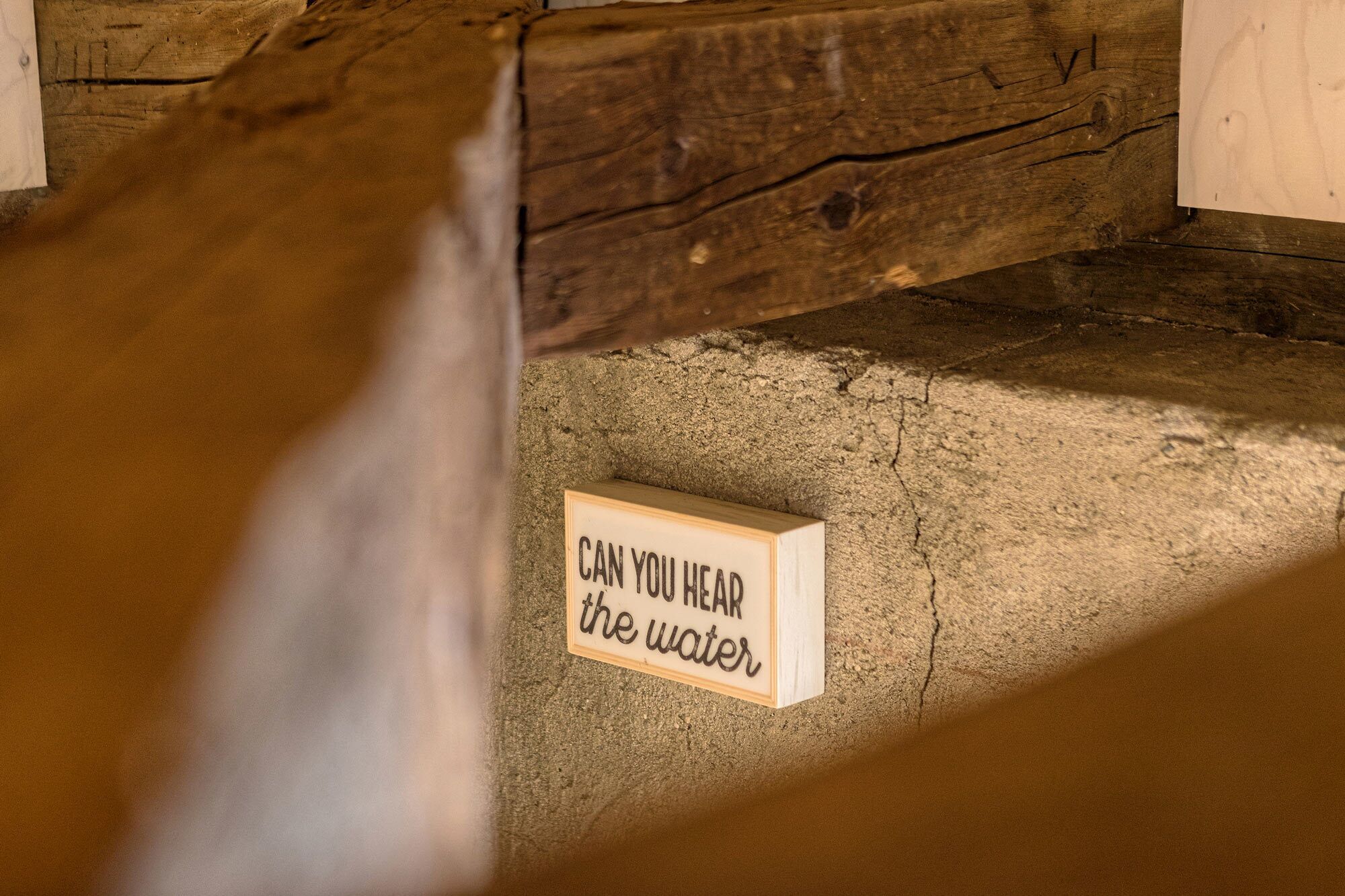 A wooden beam and a sign on the floor.