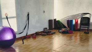Et rum med trægulv, træningsudstyr og en yogamåtte.