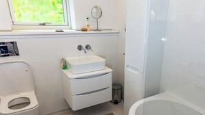 A modern bathroom with a toilet, sink, and bathtub. - 3 bedroom accommodation in Bonawe (Bonawe)