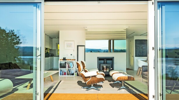 A modern interior with a fireplace, seating area, and a bookshelf. - 3 bedroom accommodation in Bonawe (Bonawe)