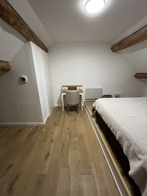 Ein Schlafzimmer mit einem Bett, einem Schreibtisch und einem Stuhl.