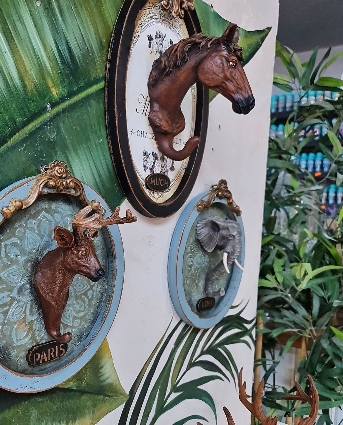 A wall with three decorative plaques: a horse, a deer, and a bird.