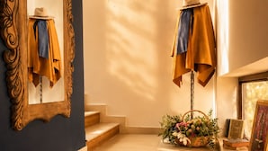 A staircase with a wooden finish, a mirror with an ornate frame, and a basket of flowers on the landing. - NovART Gallery&Sea Hotel (Sumqayit)