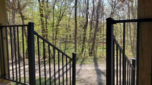 Une porte en bois qui mène à une zone boisée, avec un sentier de terre.