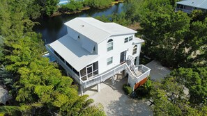Een gebouw met twee verdiepingen, een plat dak, een balkon en uitzicht op een rivier.
