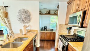 Una cocina moderna con armarios de madera, electrodomésticos de acero inoxidable y encimera de granito.