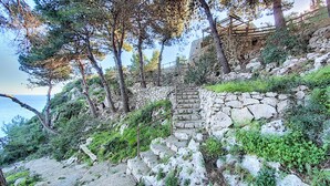 A stone staircase leading up a rocky hillside with a view of the sea. - Charming stone trullo with sea access (house F) (Castro)