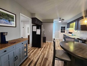 A modern kitchen with wooden flooring, a dining table, and cabinets. - Spacious Apartment in Horseheads, NY (Horseheads)