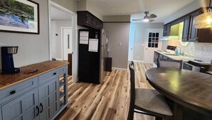 A modern kitchen with wooden flooring, a dining table, and cabinets. - Spacious Apartment in Horseheads, NY (Horseheads)