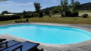 A swimming pool with a wooden deck and lounge chairs. - Renovated farmhouse with swimming pool and 3ha garden (Limeuil)