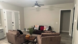 A living room with two sofas, a coffee table, and a ceiling fan.
