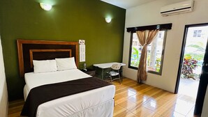 A hotel room with a bed, a small table, a chair, and a window with curtains. - Hotel California Pacific Palm (Escuintla)