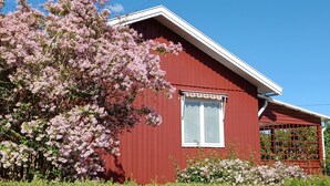 En rød bygning med et hvidt vindue og en lille veranda.
