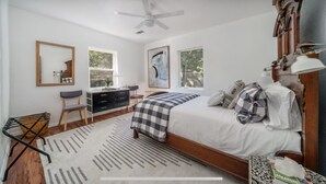 A bedroom with a bed, dresser, chair, and a ceiling fan. - Historic Uptown Retreat in Hot Springs, Arkansas (Hot Springs)