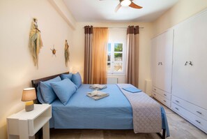A bedroom with a bed, a nightstand, a wardrobe, and a window with curtains.