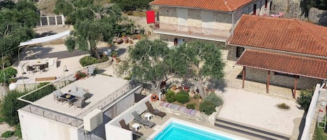 Una proprietà residenziale con piscina, area salotto esterna e giardino.