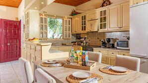 A kitchen with wooden cabinets, a microwave, and a dining table set for four.