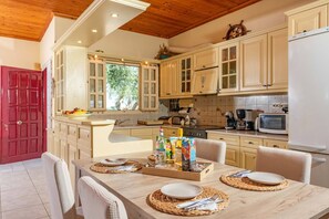 A kitchen with wooden cabinets, a microwave, and a dining table set for four.