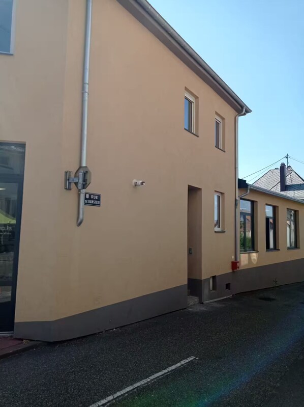 Un bâtiment de couleur beige sur lequel on peut lire l’inscription « RUE DE RAMSTEIN ».