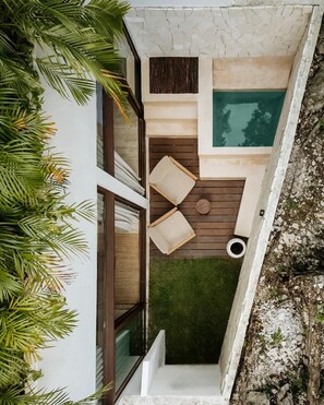 A modern outdoor living space with a pool, wooden deck, and lush greenery. - Naiik Jungle Retreat Private Pool Beach Club (Tulum)
