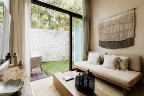 A modern interior with a sofa, a coffee table, and a wall-mounted macrame piece.