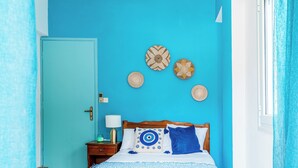 A room with a wooden bed, a teal door, and wall decor. - Double Room Apartment (Poros kefalonias)