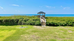 A wooden boardwalk leading to a gazebo by the beach. - Charming studio with Ocean View, AC, wifi, pool, on-site laundry room (Atlantic Beach)