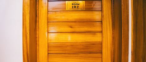 A wooden door with a sign indicating "ROOM 102".