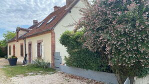 A house with a brick facade, a tiled roof, and a gravel driveway. - The little house in the village (Noyers)