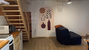 A kitchen with wooden cabinets, a built-in oven, and a microwave. There is a staircase leading to an upper level. - The little house in the village (Noyers)
