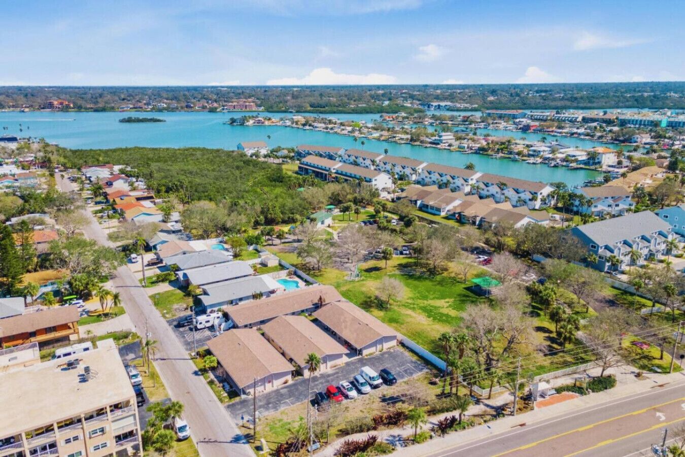 A coastal residential area with houses, a marina, and a road.