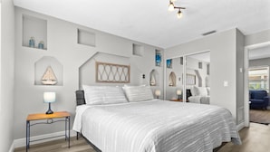 Une chambre à coucher moderne avec un grand lit, des tables de chevet et un miroir.