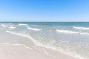 A beach with clear water and gentle waves.