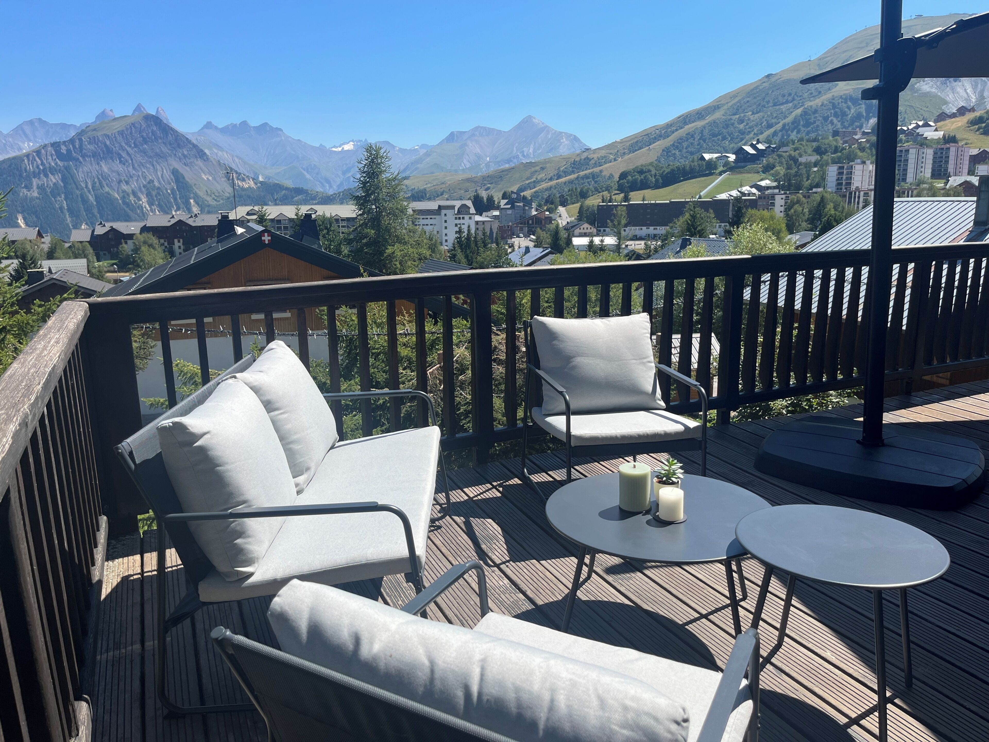 A deck with outdoor seating and a view of mountains.