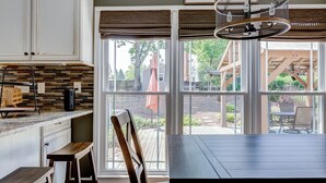 A kitchen with a large window, a dining table, and a chandelier. - Spacious Oasis with heated pool/spa, covered patio, office & near Lake Norman (Mooresville)