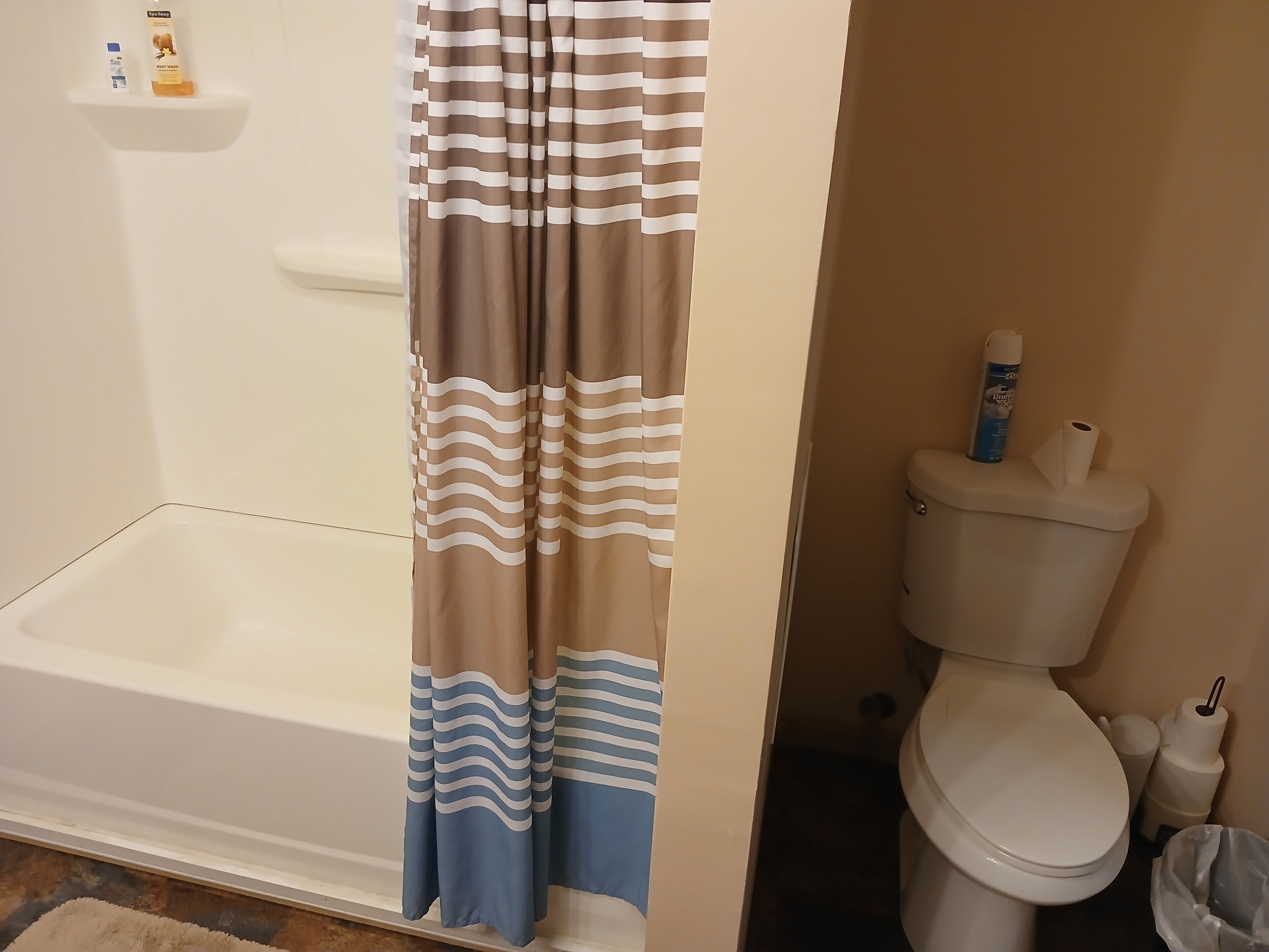 Un baño con bañera, inodoro y cortina de ducha.