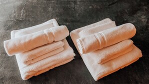 Twee stapels opgevouwen handdoeken op een structuur oppervlak.