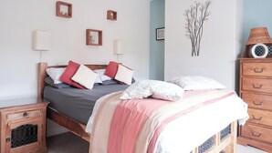 Une chambre à coucher comprenant un lit, des tables de chevet, une commode et des éléments de décoration murale.