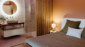 Ein modernes Badezimmer mit rundem Spiegel, Waschbecken und Dusche.