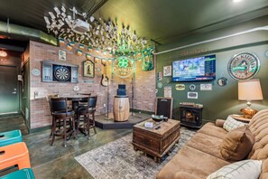A cozy pub interior with a dartboard, a wooden bar, a television, and a fireplace. - Hot Tub in Downtown! Stunning Design & Features (Nashville)