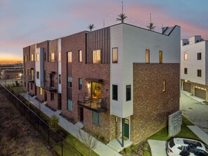 A modern multi-story residential building with a mix of brick and white siding, featuring balconies and large windows. - Hot Tub in Downtown! Stunning Design & Features (Nashville)