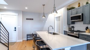 Una cocina moderna con una isla grande, electrodomésticos de acero inoxidable y un diseño minimalista.