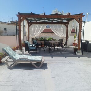 A covered outdoor seating area with a pergola, lounge chairs, and a table with chairs. - A Place in the Sun, Olhão, East Algarve (Olhão)
