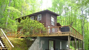 A cabin with a wooden deck, a staircase, and a door leading to an interior space. - Locust Flats - PET-FRIENDLY MOUNTAIN Cabin = Decks-Views-Firepit (Franklin)
